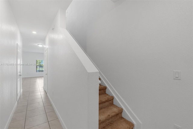 stairs with tile patterned floors and baseboards