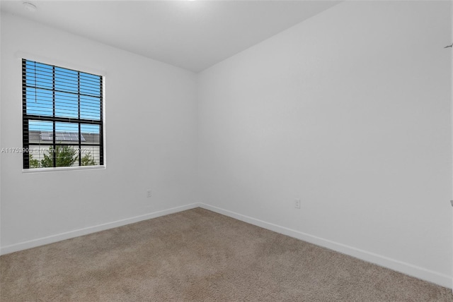 spare room with carpet and baseboards