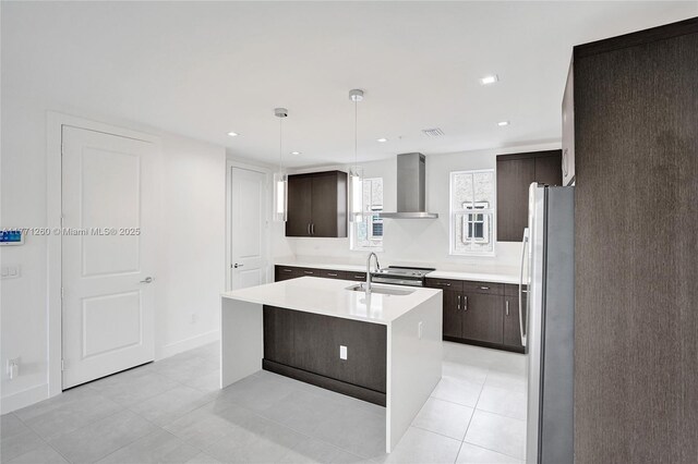 63 NW 4th Ave, Delray Beach, FL 33444 - kitchen featuring a kitchen island with sink, wall chimney exhaust hood, dark brown cabinets, a sink, and freestanding refrigerator
