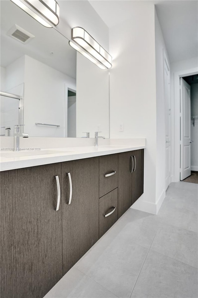 63 NW 4th Ave, Delray Beach, FL 33444 - bathroom with a sink, a shower with shower door, baseboards, visible vents, and double vanity