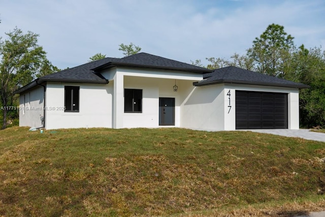 prairie-style house featuring stucco siding, an attached garage, a front yard, and driveway