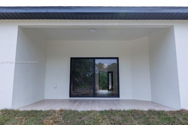 view of exterior entry featuring stucco siding