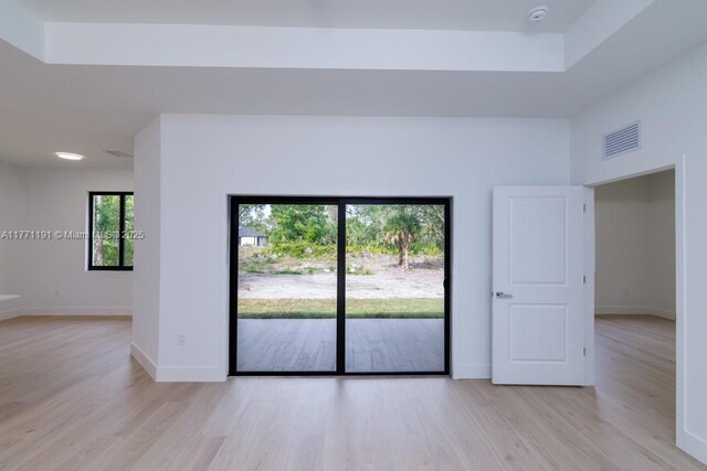 unfurnished room featuring baseboards, visible vents, and light wood-type flooring