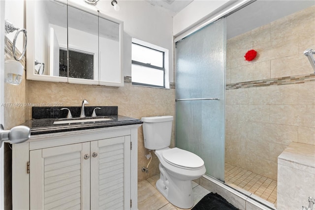 full bath with vanity, tile walls, toilet, tile patterned floors, and tiled shower