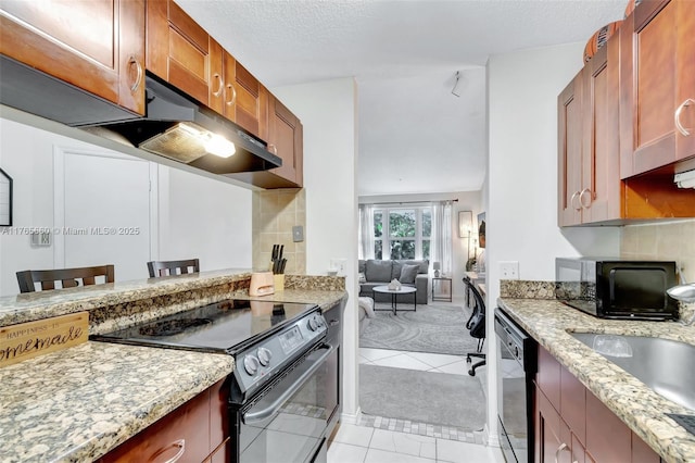 2307 N Congress Ave Unit 28, Boynton Beach, FL 33426 - kitchen featuring black appliances, under cabinet range hood, light stone countertops, and a sink