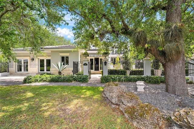 3916 Granada Blvd, Coral Gables, FL 33134 - view of front of house featuring french doors, stucco siding, a front yard, and a fenced front yard