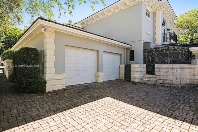 3916 Granada Blvd, Coral Gables, FL 33134 - view of property exterior with decorative driveway, stucco siding, an attached garage, and stone siding