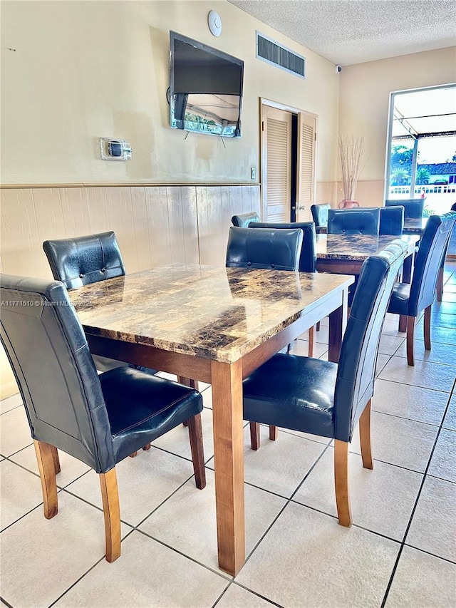 3161 S Ocean Dr Unit 708, Hallandale Beach, FL 33009 - dining space featuring a wainscoted wall, light tile patterned floors, a textured ceiling, and visible vents