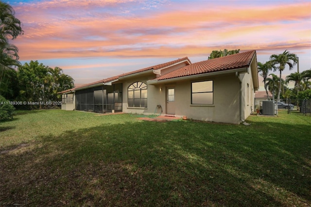 19460 NW 8th St, Pembroke Pines, FL 33029 - back of property at dusk featuring a tiled roof, central air condition unit, stucco siding, and a sunroom
