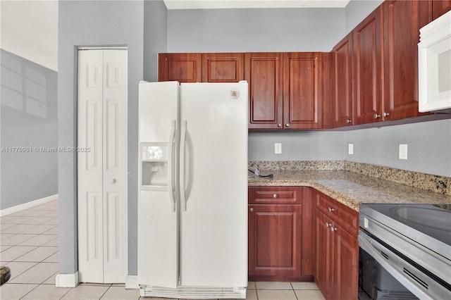 374 NE 26th Ave Unit 203, Homestead, FL 33033 - kitchen featuring light tile patterned flooring, light stone countertops, and white appliances
