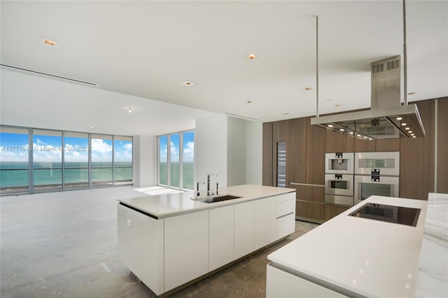 18501 Collins Ave Unit 1804, Sunny Isles Beach, FL 33160 - kitchen featuring modern cabinets, island range hood, a sink, white cabinets, and black electric cooktop