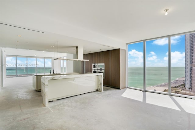 18501 Collins Ave Unit 1804, Sunny Isles Beach, FL 33160 - kitchen with unfinished concrete flooring, a water view, modern cabinets, a spacious island, and floor to ceiling windows