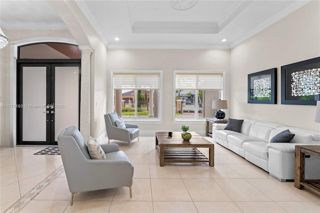living room featuring ornate columns, arched walkways, light tile patterned flooring, ornamental molding, and a raised ceiling