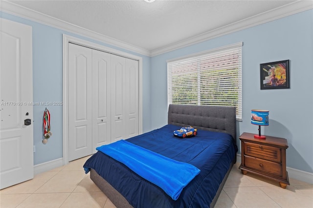 bedroom featuring crown molding, baseboards, light tile patterned floors, a closet, and a textured ceiling