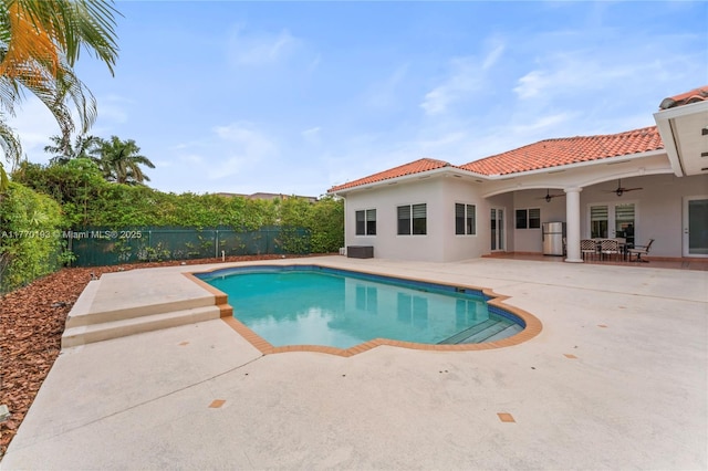 view of swimming pool with a ceiling fan, a fenced backyard, and a patio area