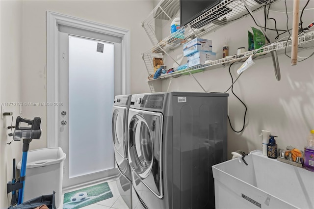laundry room featuring washing machine and clothes dryer and tile patterned flooring