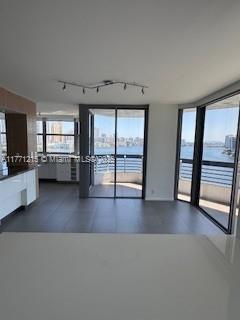 19101 NE Mystic Pointe Dr Unit 1601, Aventura, FL 33180 - unfurnished living room with track lighting, a water view, and healthy amount of natural light