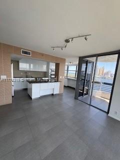 19101 NE Mystic Pointe Dr Unit 1601, Aventura, FL 33180 - kitchen featuring white cabinets and track lighting