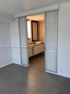 19101 NE Mystic Pointe Dr Unit 1601, Aventura, FL 33180 - empty room featuring dark tile patterned flooring and baseboards