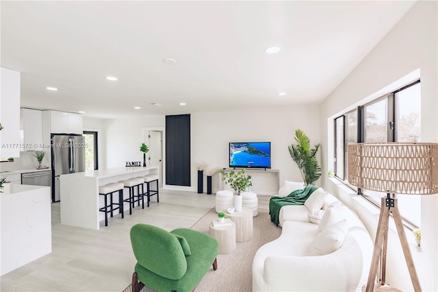 living room with light wood-style flooring and recessed lighting