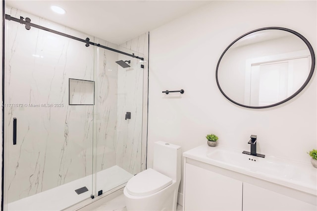 bathroom with toilet, a marble finish shower, and vanity