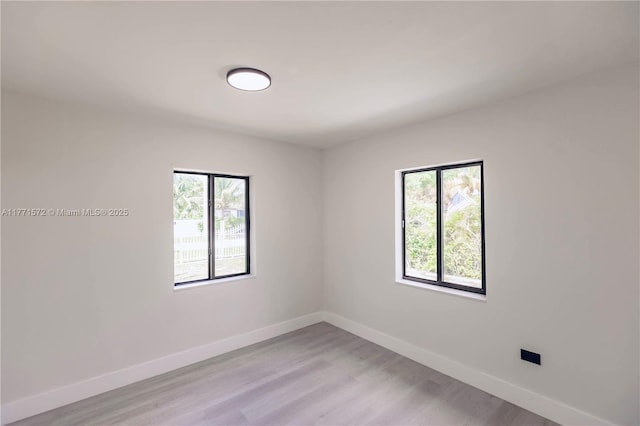 empty room featuring light wood-style flooring and baseboards