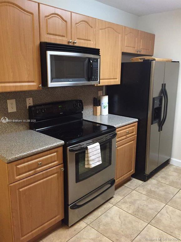 kitchen with light tile patterned flooring and stainless steel appliances