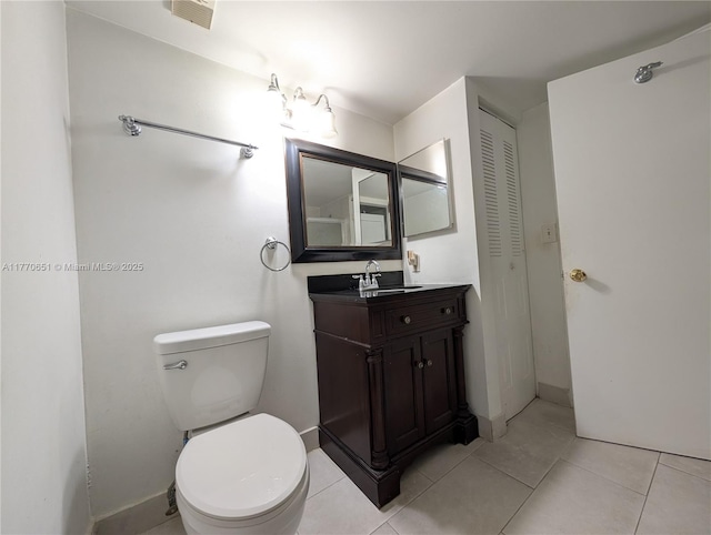 bathroom featuring a closet, vanity, visible vents, toilet, and tile patterned floors