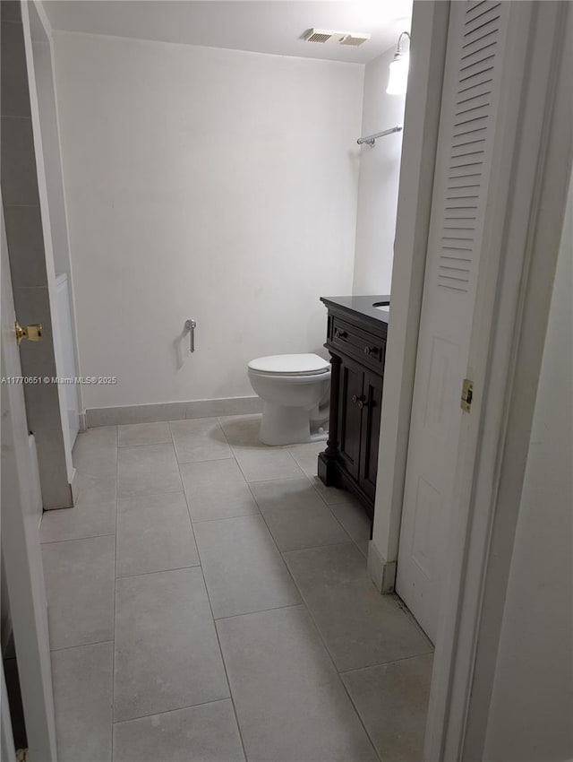 bathroom featuring tile patterned flooring, vanity, visible vents, and toilet