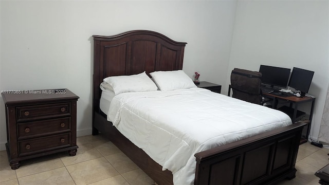 bedroom with light tile patterned floors and baseboards