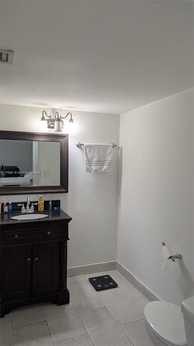half bathroom featuring vanity, tile patterned flooring, visible vents, toilet, and baseboards