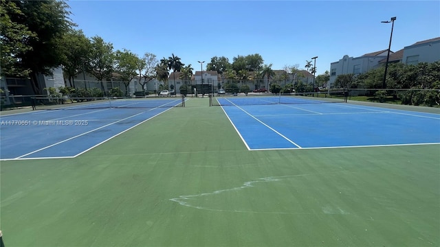view of sport court with fence and a residential view