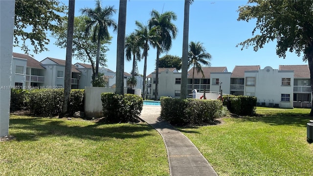 view of home's community with a swimming pool, a residential view, and a yard