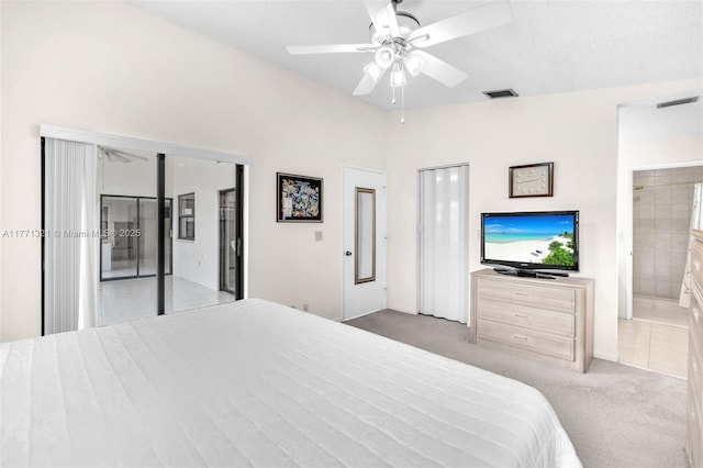 tiled bedroom featuring connected bathroom, visible vents, lofted ceiling, and carpet floors