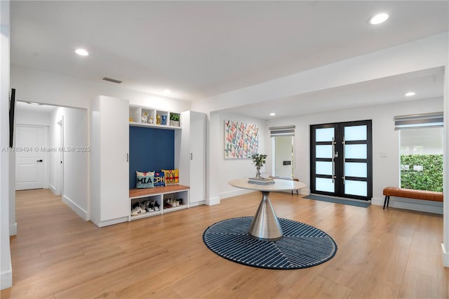 foyer featuring french doors, visible vents, baseboards, light wood finished floors, and recessed lighting