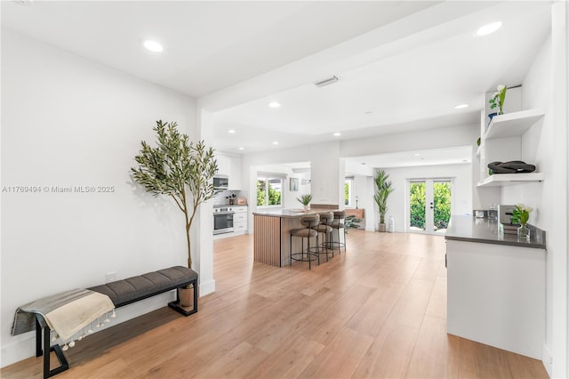 3291 SW 16th Ln, Miami, FL 33145 - kitchen with open shelves, white cabinets, a breakfast bar, french doors, and appliances with stainless steel finishes