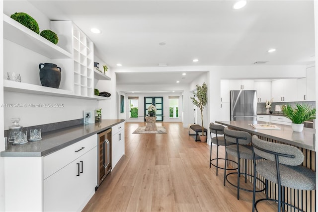 3291 SW 16th Ln, Miami, FL 33145 - kitchen with freestanding refrigerator, wine cooler, dark countertops, open shelves, and light wood-style floors