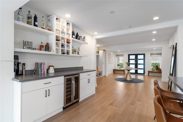 bar with recessed lighting, light wood-type flooring, bar area, and wine cooler