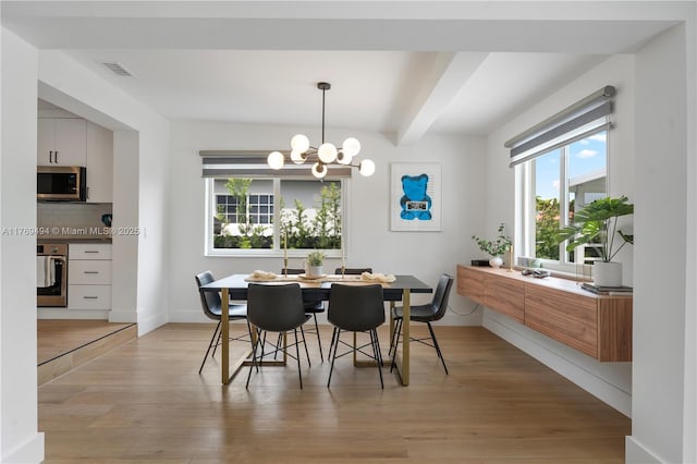 dining room featuring visible vents, baseboards, beamed ceiling, light wood finished floors, and an inviting chandelier
