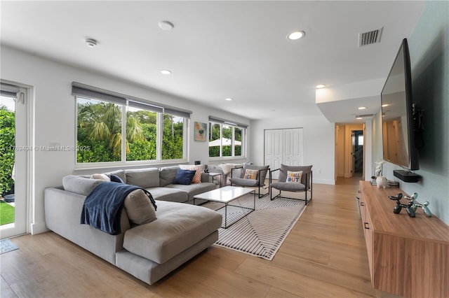living area featuring recessed lighting, light wood-style flooring, and visible vents