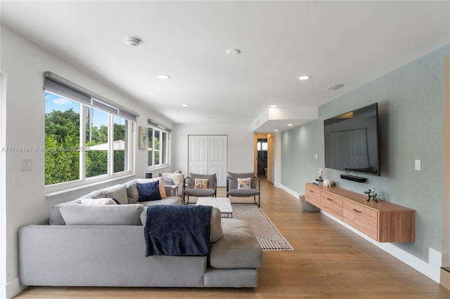 living room featuring light wood-type flooring, recessed lighting, baseboards, and visible vents