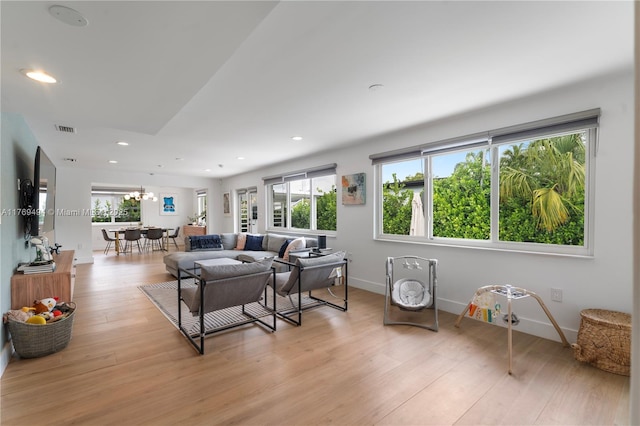 living room featuring visible vents, recessed lighting, light wood-style flooring, and a notable chandelier