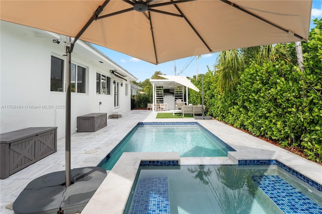 view of swimming pool featuring a patio, a pool with connected hot tub, and an outdoor hangout area