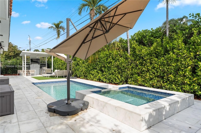 pool with exterior kitchen, an in ground hot tub, and a patio