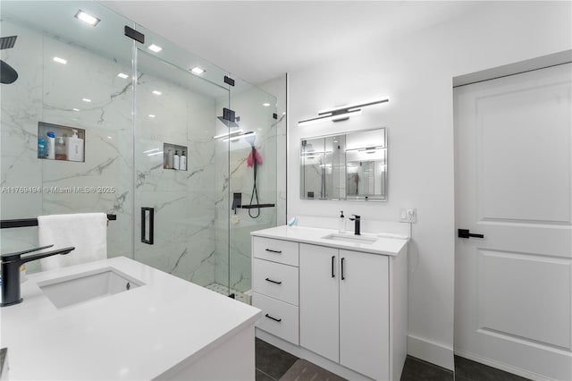 full bathroom featuring vanity, a marble finish shower, and baseboards