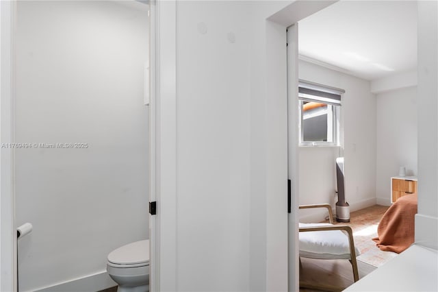 bathroom featuring baseboards and toilet