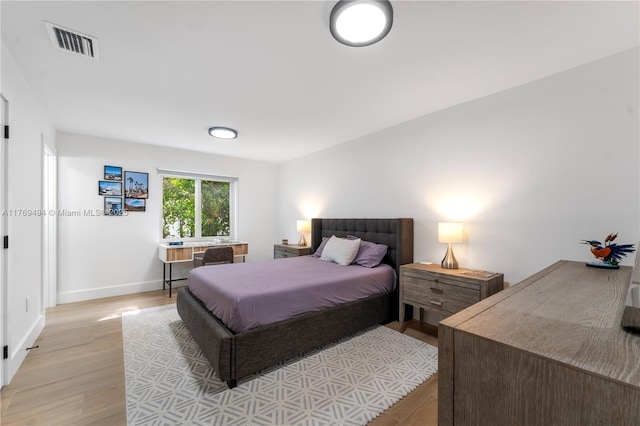 bedroom with baseboards, visible vents, and light wood-type flooring
