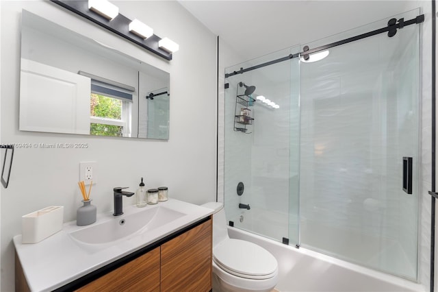 bathroom featuring toilet, shower / bath combination with glass door, and vanity