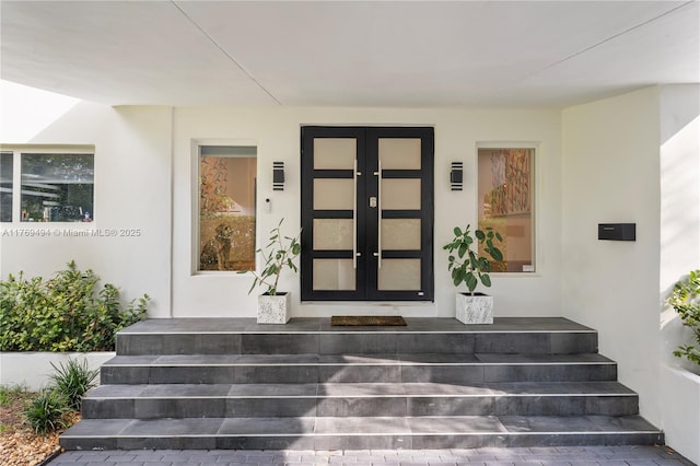 entrance to property with stucco siding and french doors