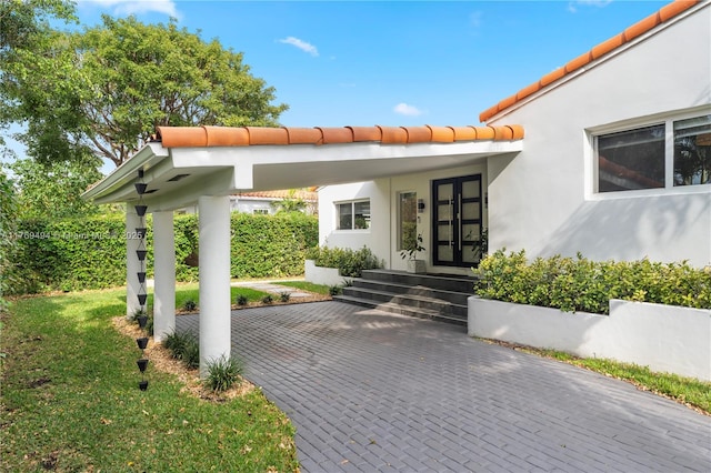 property entrance with stucco siding and a tiled roof